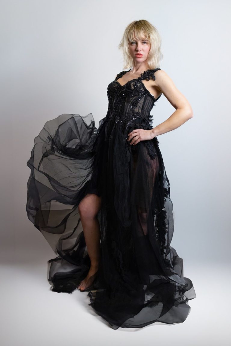 Frau in einem langen, transparenten schwarzen Kleid mit fließendem Stoff.
